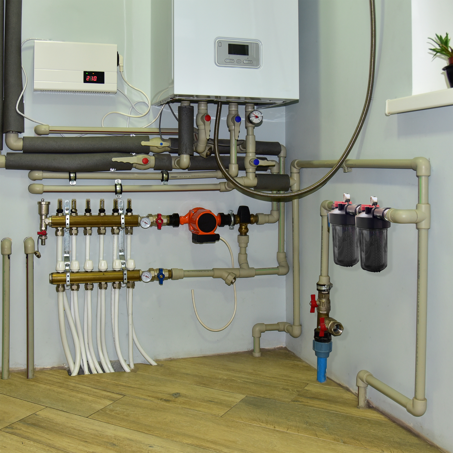 Heating system with pipes and control panels on a wall.